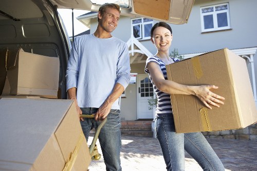 Team removing a sofa and bed frame during local furniture pick-up